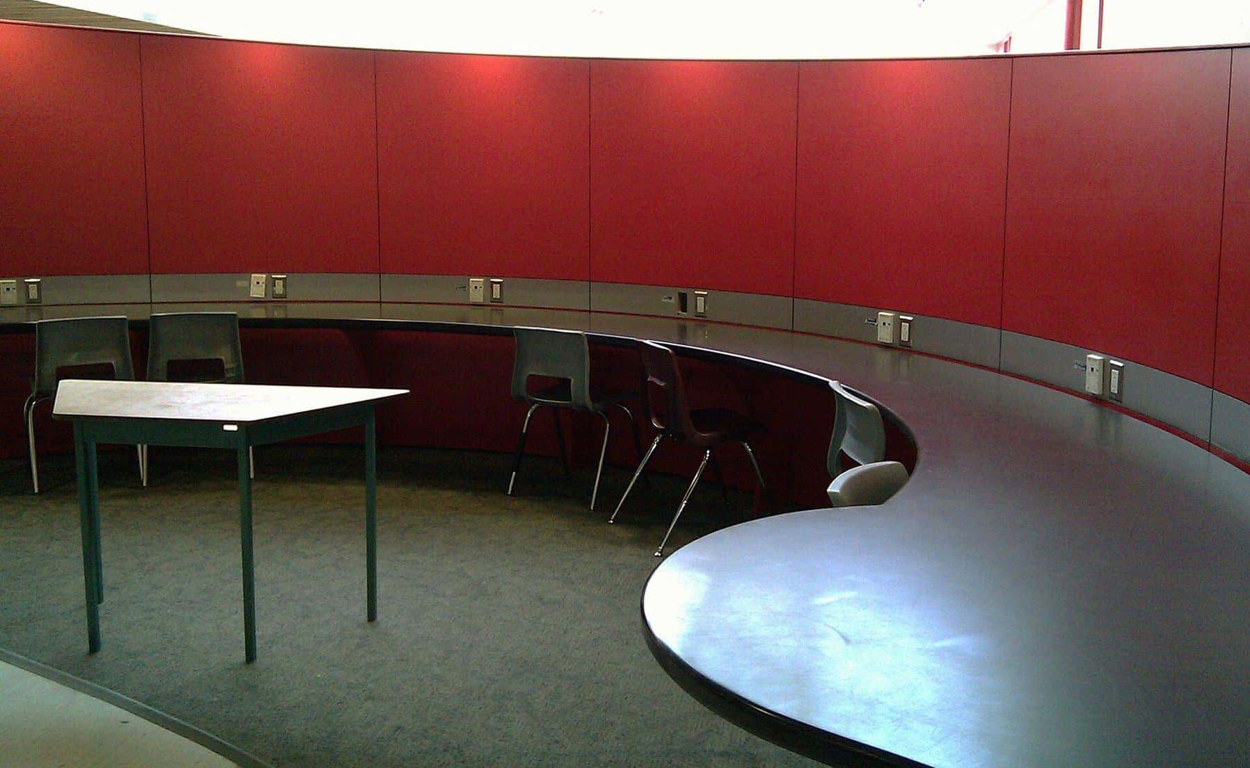 A quiet university study area with laptops on long desks